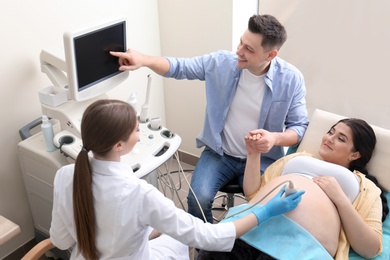 Photo of Man supporting his wife during ultrasound scan in clinic