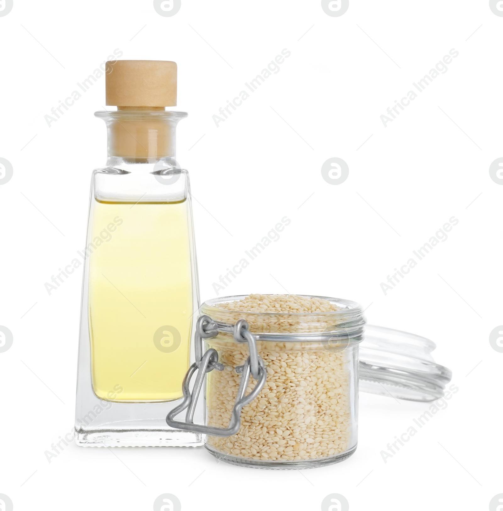 Photo of Glass bottle of fresh sesame oil and jar with seeds isolated on white