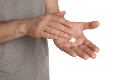 Man applying cream onto hand against white background, closeup