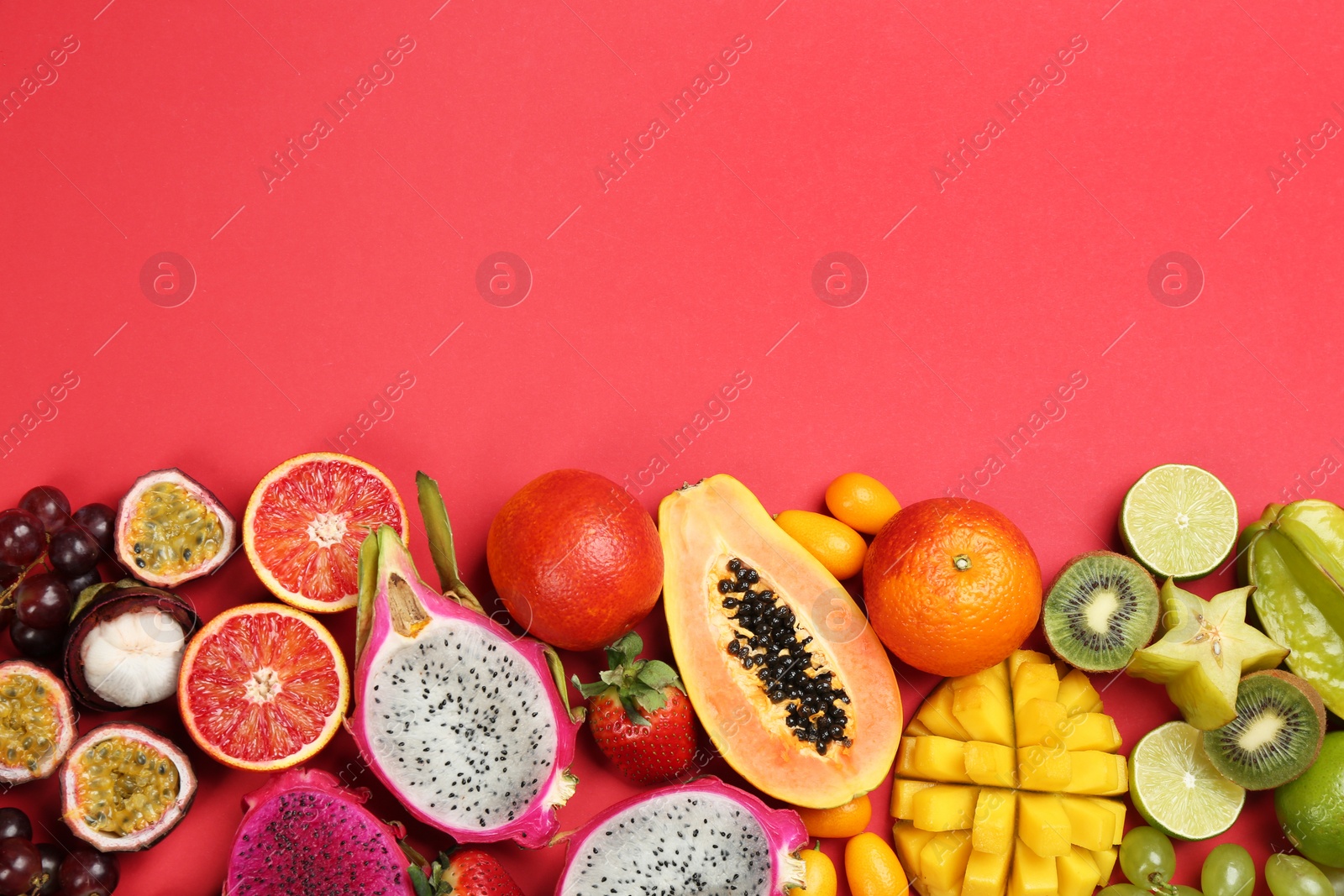 Photo of Many different delicious exotic fruits on red background, flat lay. Space for text