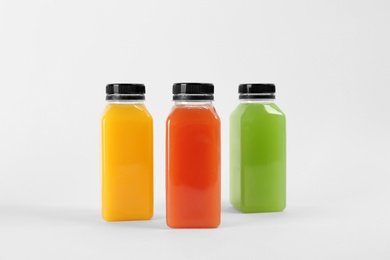 Photo of Bottles with delicious colorful juices on white background