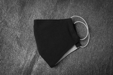 Photo of Homemade protective face mask on grey stone table, top view