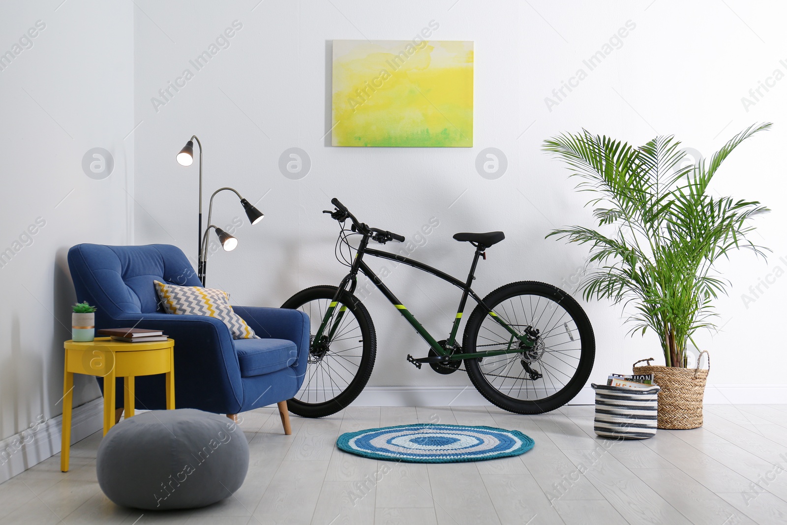 Photo of Modern bicycle and comfortable armchair in stylish living room interior