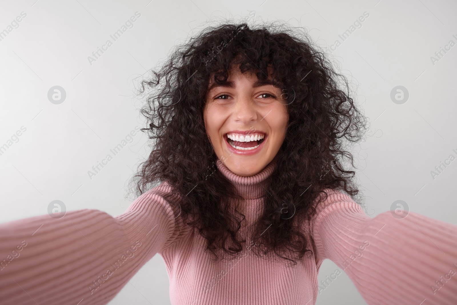 Photo of Beautiful young woman taking selfie on light grey background