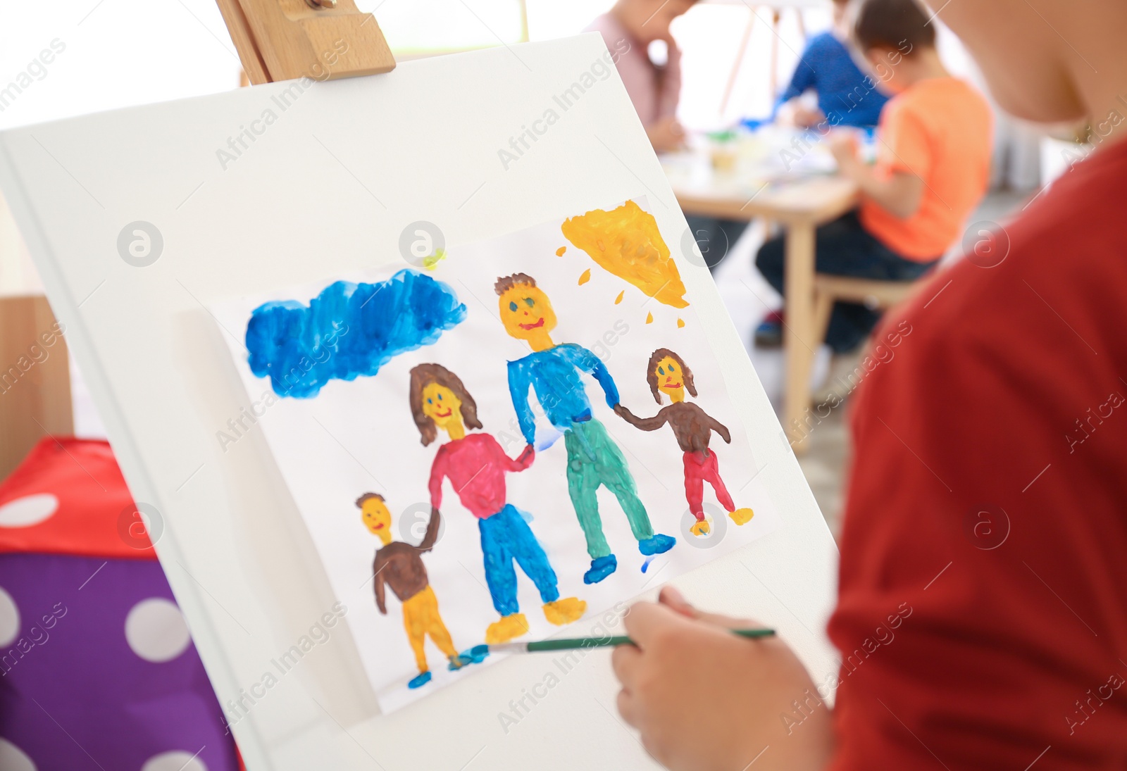 Photo of Little child painting family indoors, closeup view