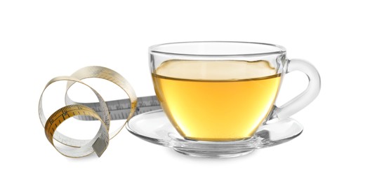 Photo of Glass cup of diet herbal tea and measuring tape on white background