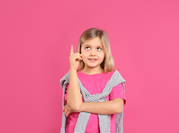 Photo of Cute little girl wearing casual outfit on pink background