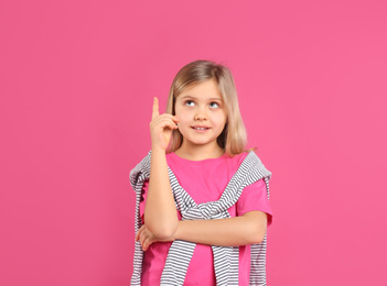 Cute little girl wearing casual outfit on pink background