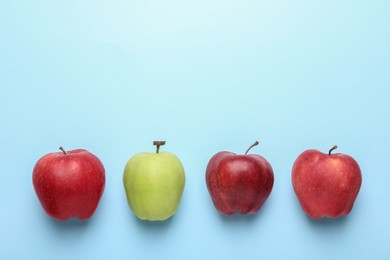 Photo of Ripe red and green apples on light blue background, flat lay. Space for text
