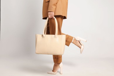 Young woman with stylish bag on white background, closeup