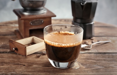 Glass of aromatic hot coffee on table