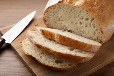 Photo of Cut tasty wheat sodawater bread on wooden table, closeup