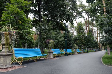 Photo of Beautiful view of park with blue wooden benches