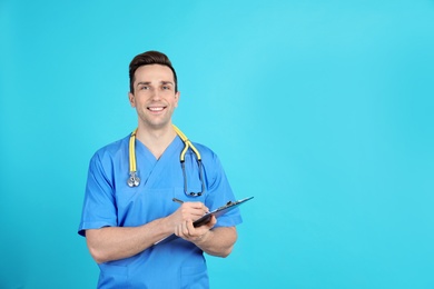 Portrait of medical assistant with stethoscope and clipboard on color background. Space for text