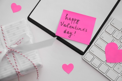 Photo of Memory sticker with phrase Happy Valentine's Day on clipboard at table, flat lay