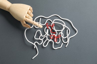 Photo of Amnesia problem. Brain made of wires and mannequin hand on grey background, top view
