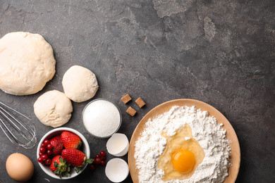 Flat lay composition with dough on grey table, space for text. Cooking pastries