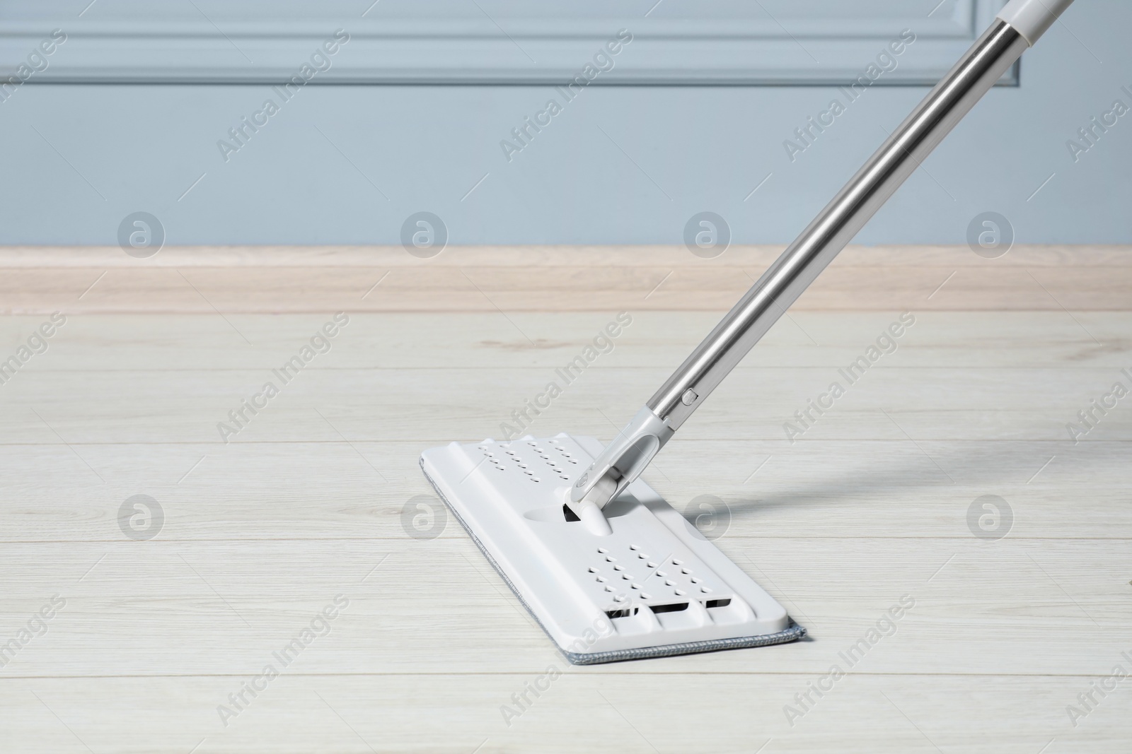 Photo of Cleaning of parquet floor with mop indoors