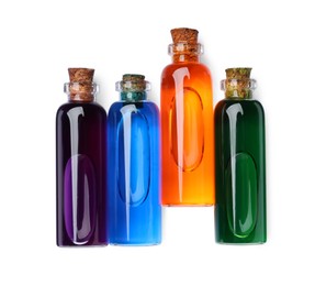 Glass bottles with different food coloring on white background, top view