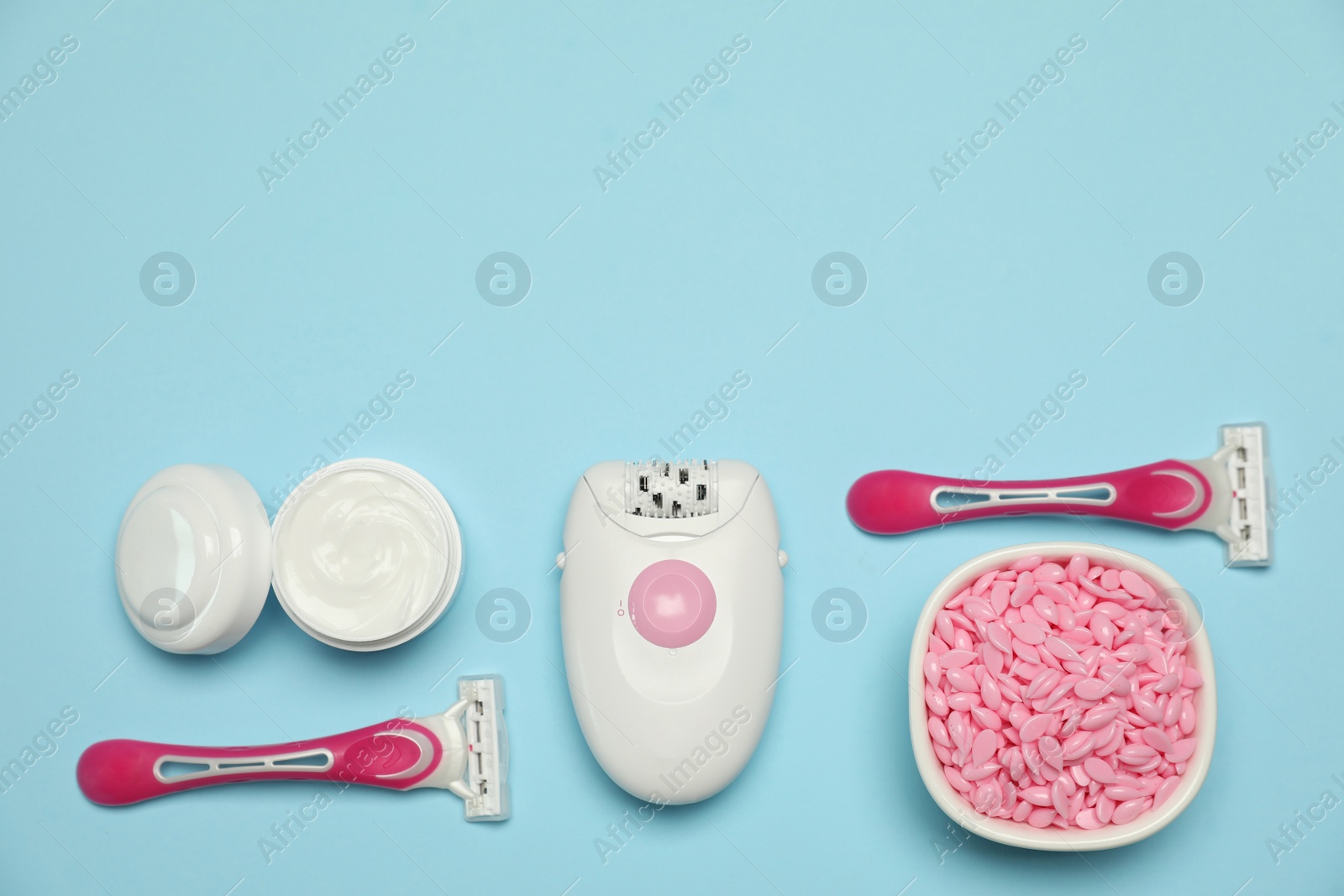 Photo of Flat lay composition with epilator and other hair removal products on light blue background. Space for text