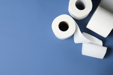 Toilet paper rolls and space for text on color background, top view