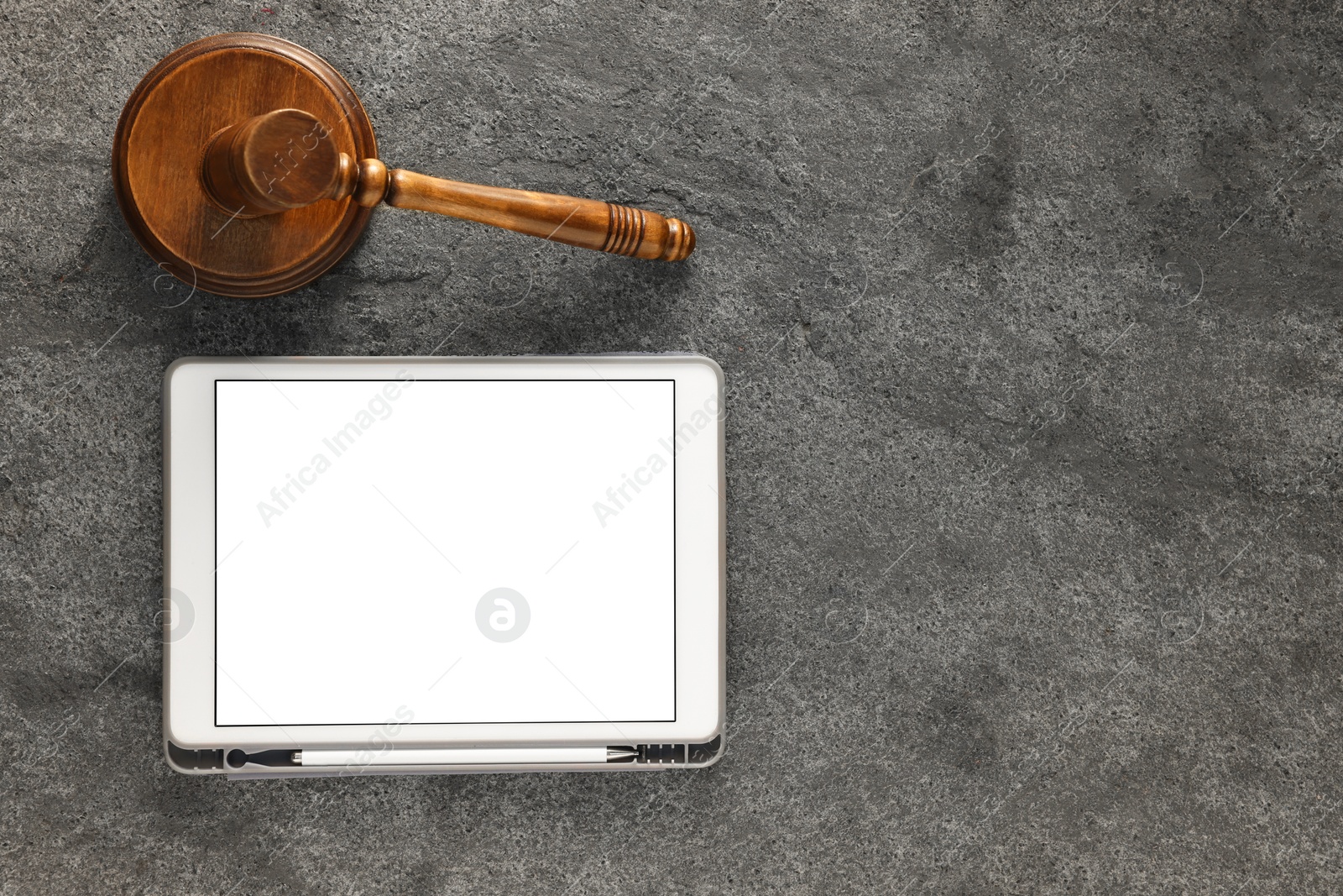 Photo of Modern tablet and gavel on gray textured table, flat lay. Space for text