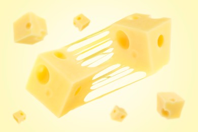 Pieces of cheese falling on yellow background