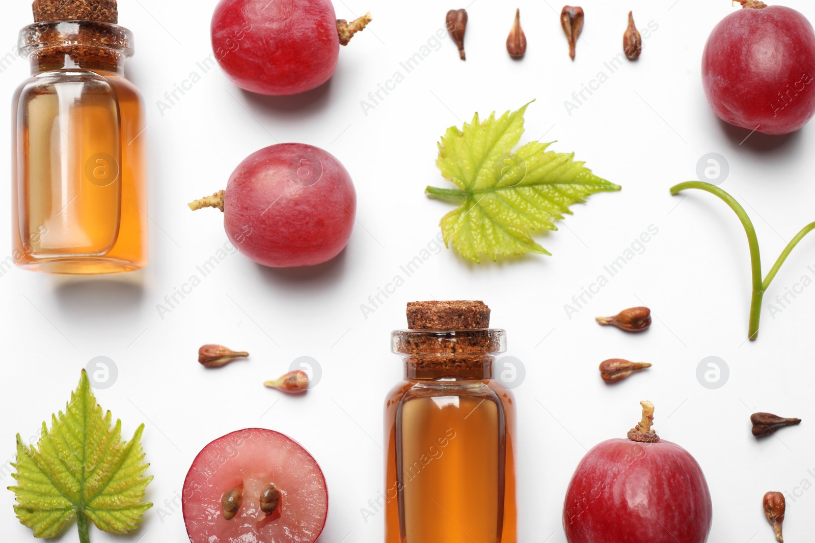 Photo of Flat lay composition with natural grape seed essential oil on white background. Organic cosmetics