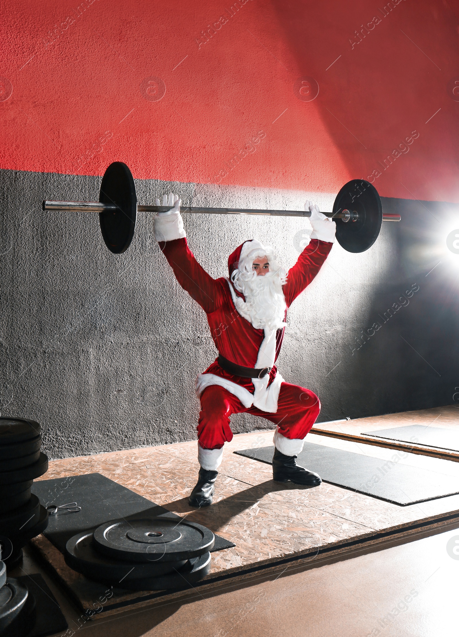 Photo of Young Santa Claus training in modern gym