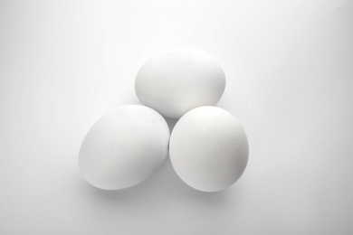 Photo of Few raw chicken eggs on white background