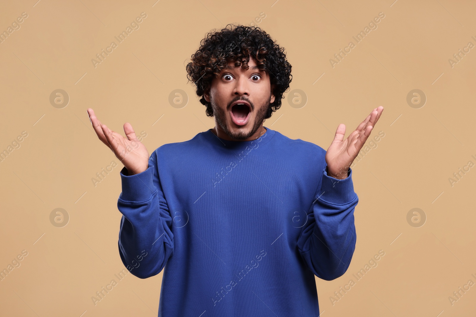 Photo of Handsome surprised man on beige background. Space for text