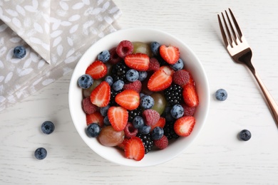 Photo of Fresh tasty fruit salad on white wooden table, flat lay