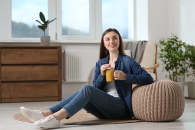 Photo of Beautiful young woman with delicious smoothie on floor at home. Space for text