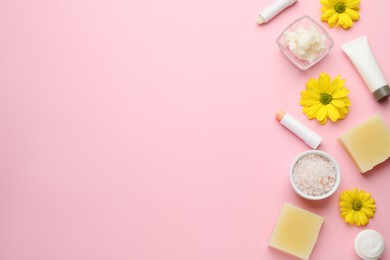 Photo of Flat lay composition with beeswax and cosmetic products on pink background. Space for text