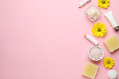 Flat lay composition with beeswax and cosmetic products on pink background. Space for text