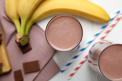 Fresh yummy chocolate milk on white table, flat lay