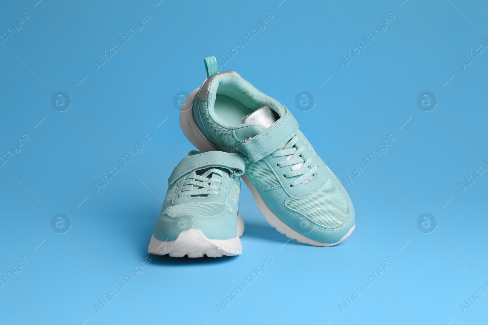 Photo of Pair of stylish sneakers on light blue background