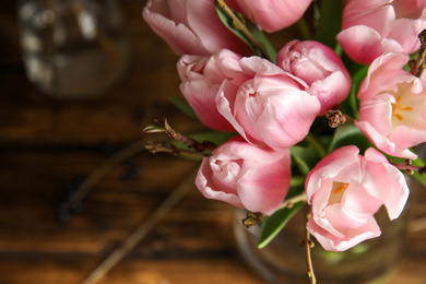 Photo of Beautiful bouquet with spring pink tulips on table, above view