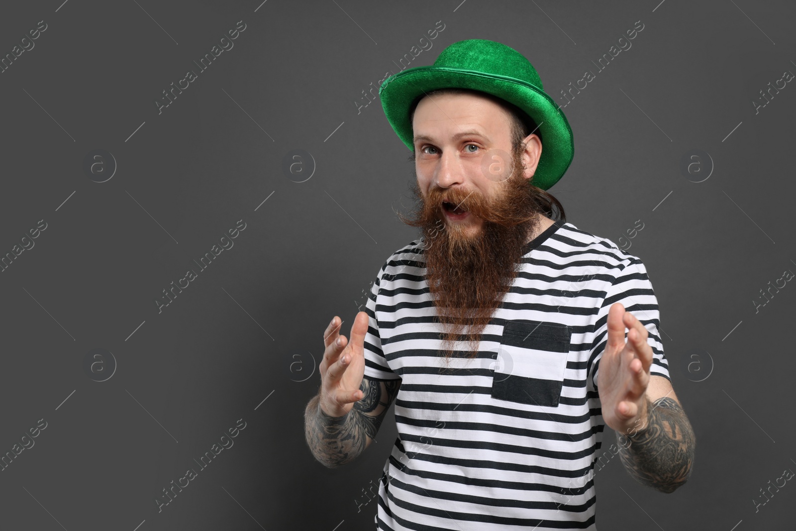 Photo of Bearded man with green hat on grey background, space for text. St. Patrick's Day celebration