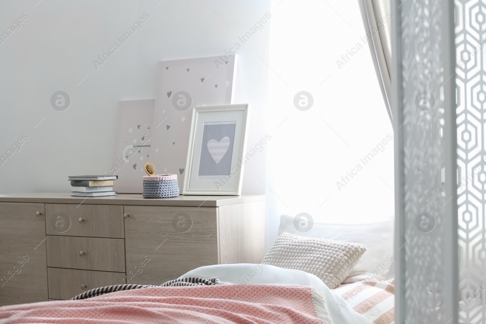 Photo of Modern chest of drawers in beautiful bedroom. Interior design