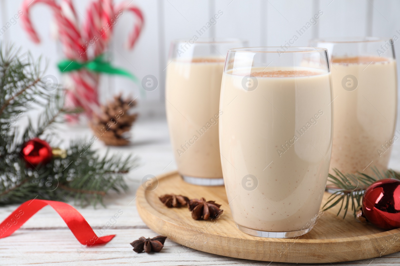 Photo of Delicious Christmas cocktail with liqueur on white wooden table, closeup. Space for text