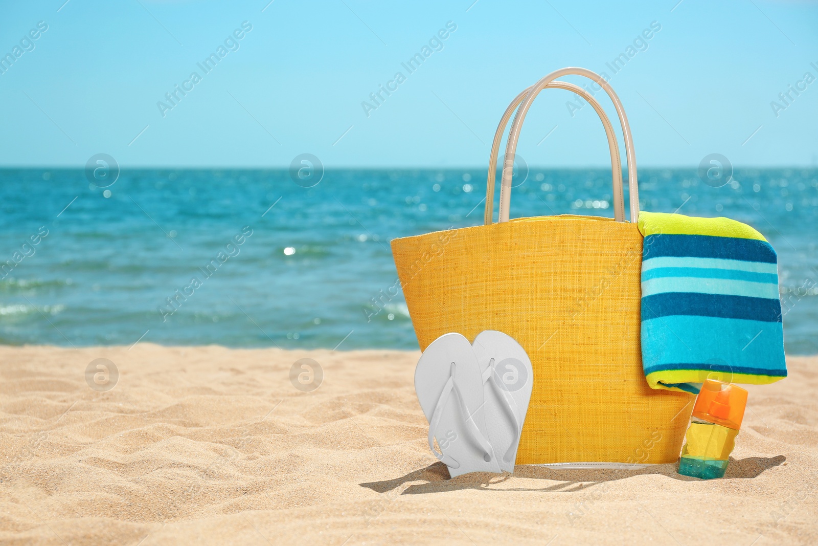 Photo of Set of different beach objects on sand near sea. Space for text