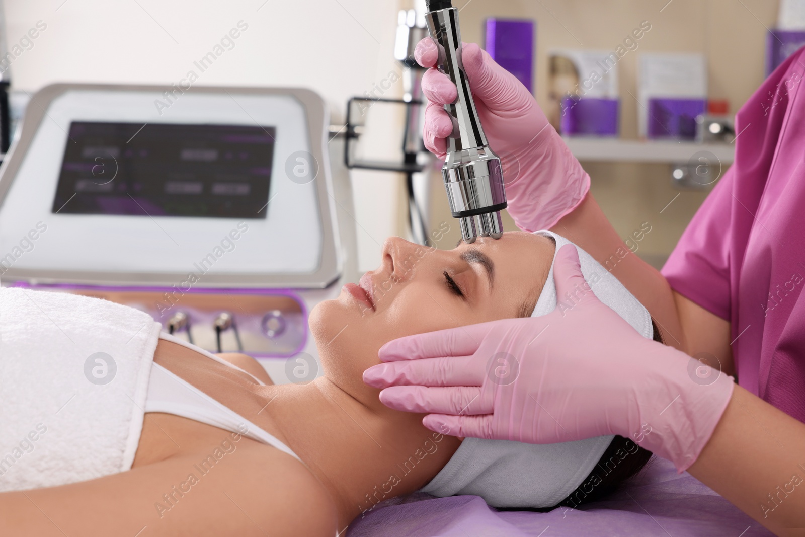 Photo of Young woman undergoing cosmetic procedure in beauty salon. Microcurrent therapy