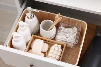 Different bath accessories and personal care products in drawer indoors, above view