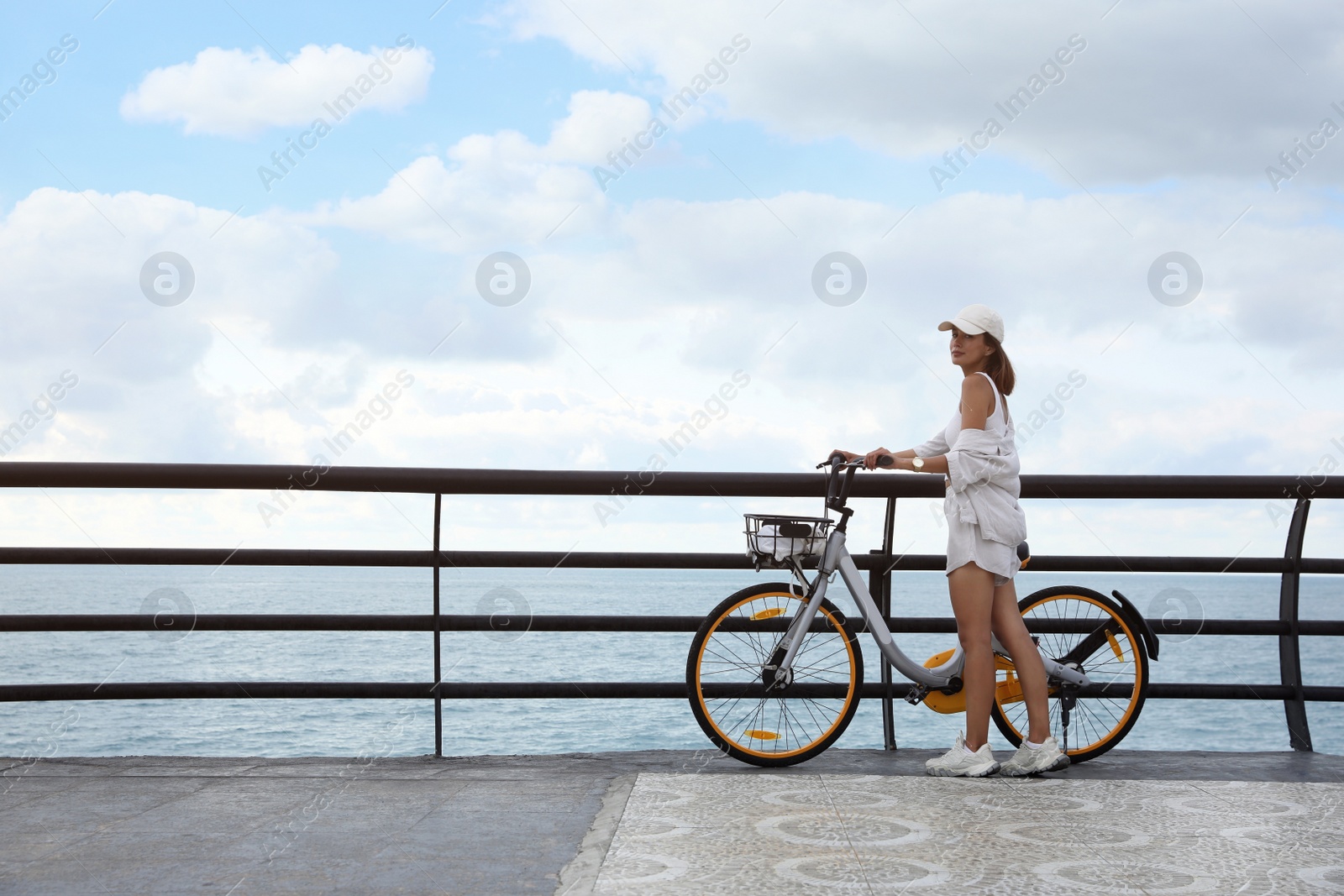 Photo of Beautiful young woman with bicycle near sea. Space for text