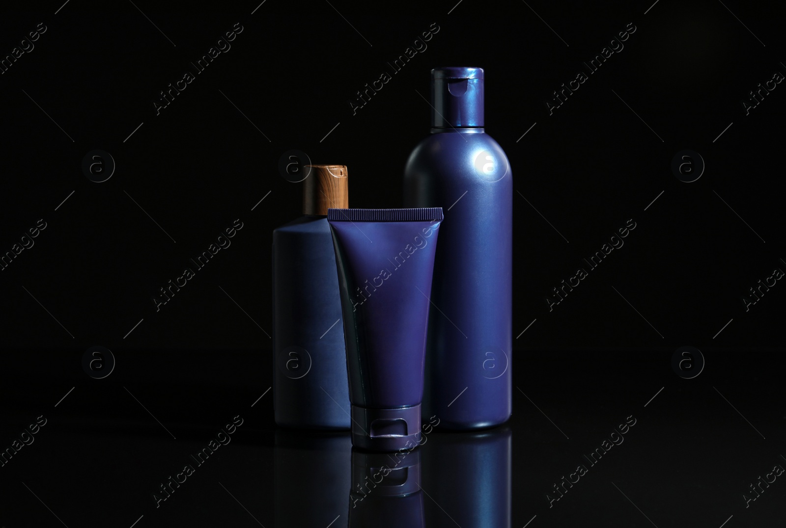 Photo of Facial cream and other men's cosmetic products on black background