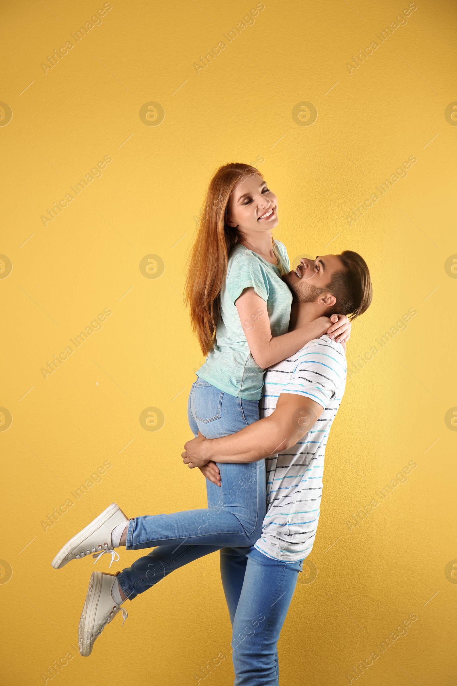 Photo of Young couple in stylish jeans on color background