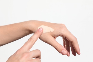 Photo of Woman testing foundation tone on hand, closeup