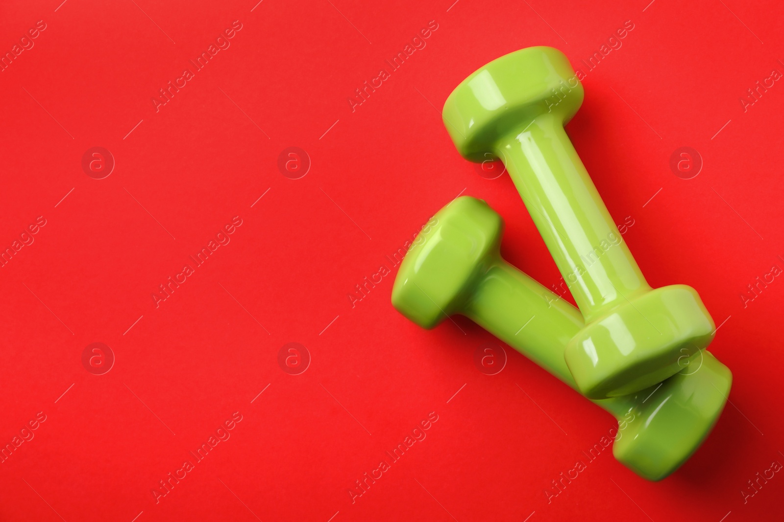 Photo of Bright dumbbells and space for text on color background, flat lay. Home fitness