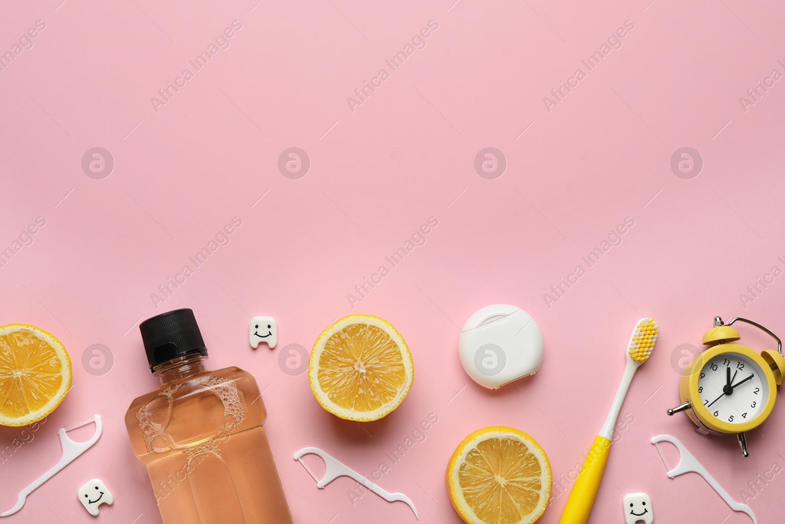 Photo of Flat lay composition with mouthwash and others oral hygiene products on pink background. Space for text